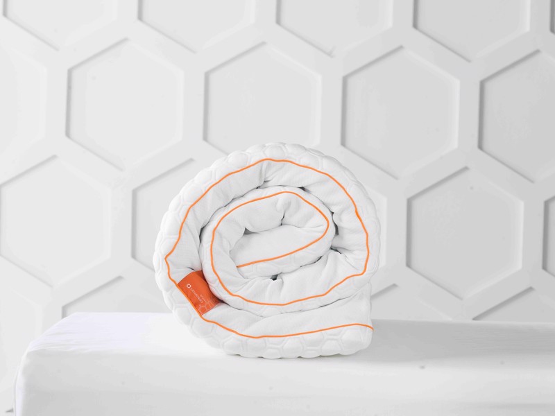 Dormeo Octasmart Deluxe topper rolled up in a bright room