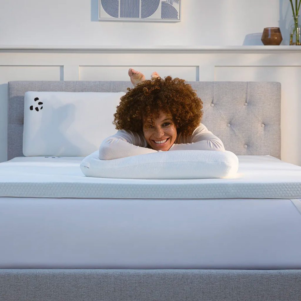 Woman lying on a double bed fitted with the Panda Bamboo Mattress Topper