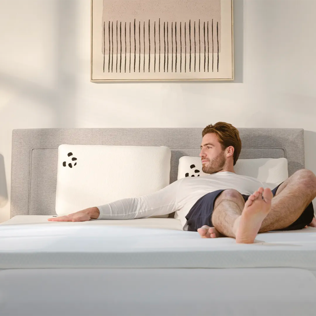 Man lying on a double bed fitted with the Panda Bamboo Mattress Topper