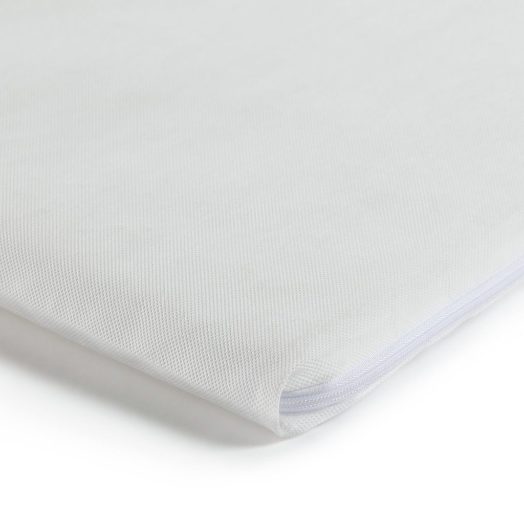 Corner of the Cuggl travel cot mattress showing the zip on the removable cover