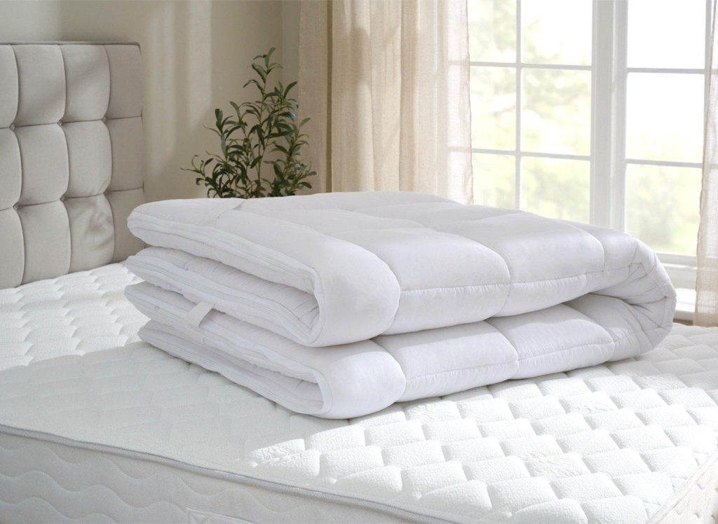 Dream Team Ultimate Washable Mattress Topper folded on a bed