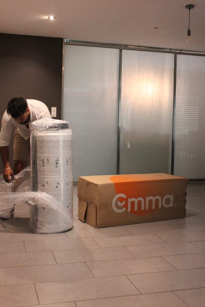 Unboxing the Emma Original: the rolled mattress next to its Emma box
