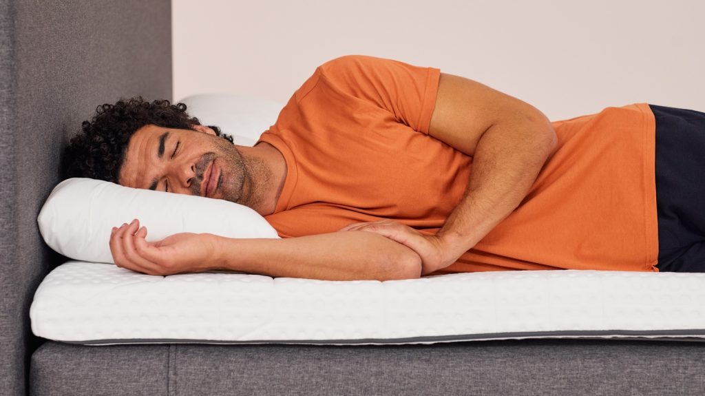 Man sleeping on his side on the Emma Original Topper