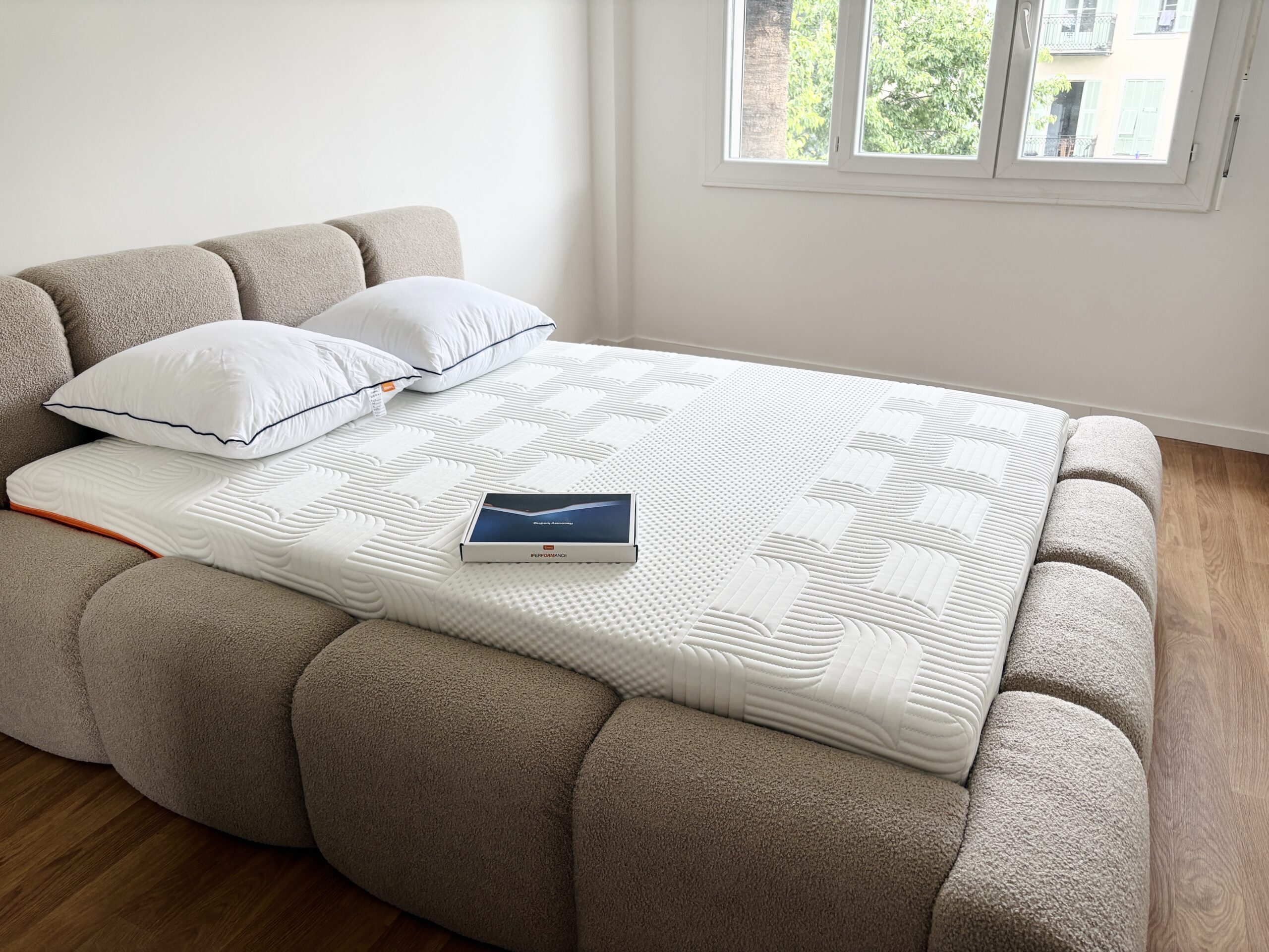 The Emma Performance in our test bedroom, on an upholstered bed with two pillows