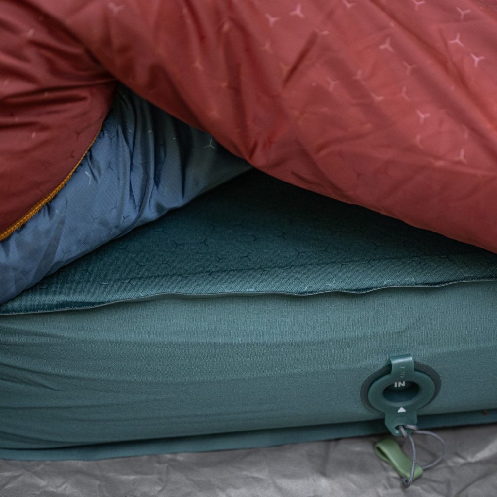 Exped MegaMat in a tent with a sleeping bag, showing its inflation valve
