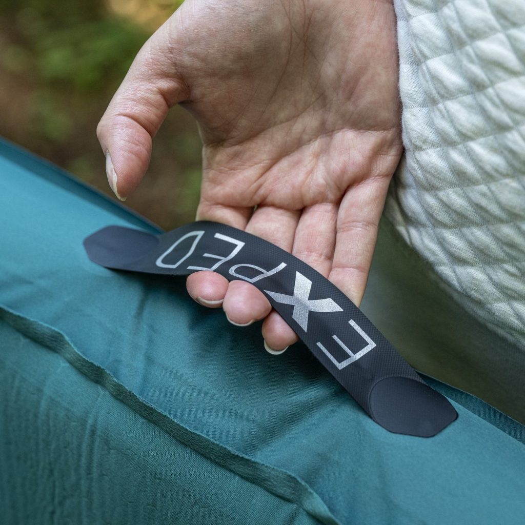 Hand holding the side handle of the Exped MegaMat