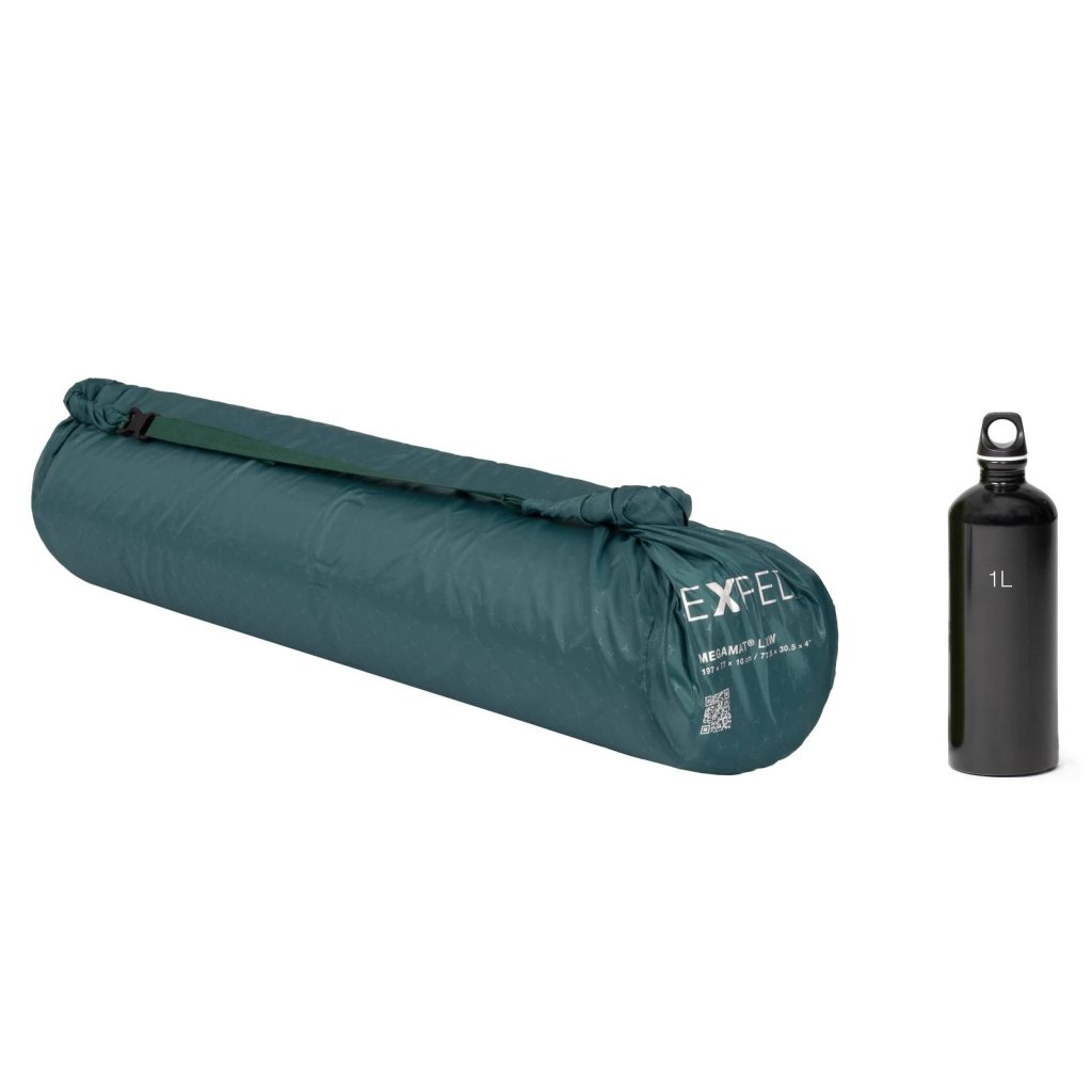 Exped MegaMat packed in its bag beside a bottle for scale