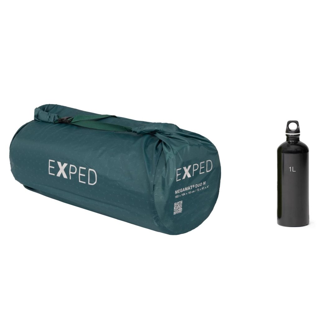 Exped MegaMat Duo packed in its bag beside a bottle for scale