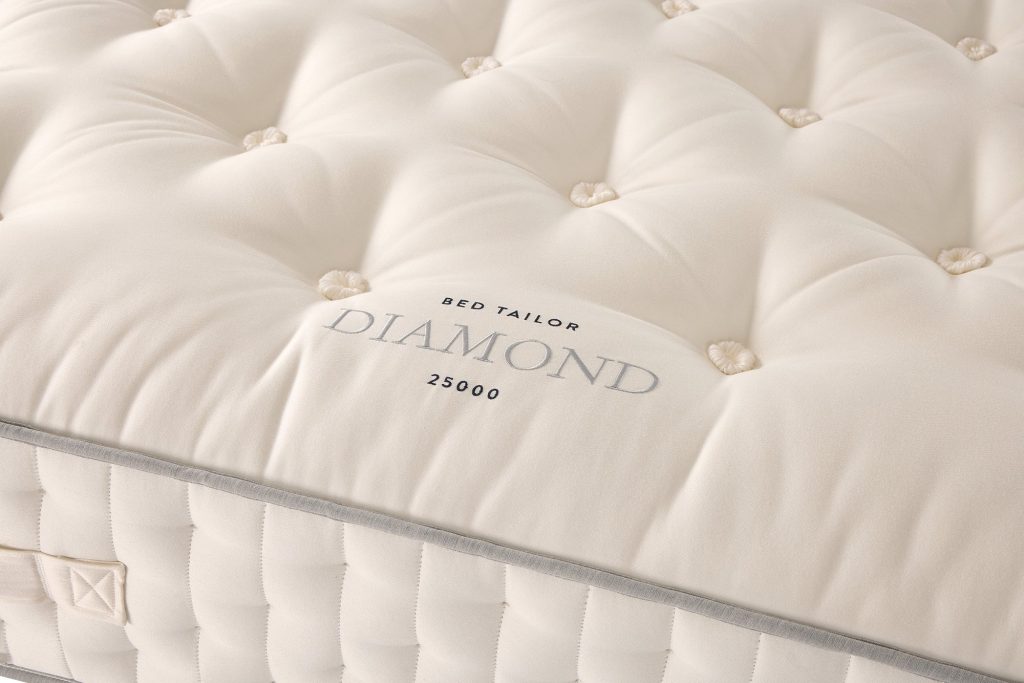 Close-up of the embroidered Diamond 25000 label and tufting on the mattress top