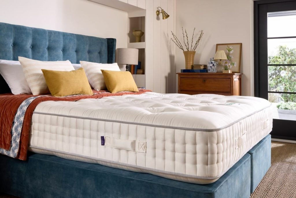 Harrison Spinks Emerald 16500 mattress on a blue upholstered divan in a bedroom