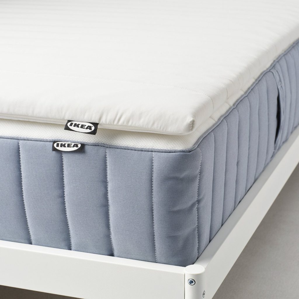 IKEA Näsfjället mattress pad on a blue sprung mattress, side view of the 4 cm foam layer