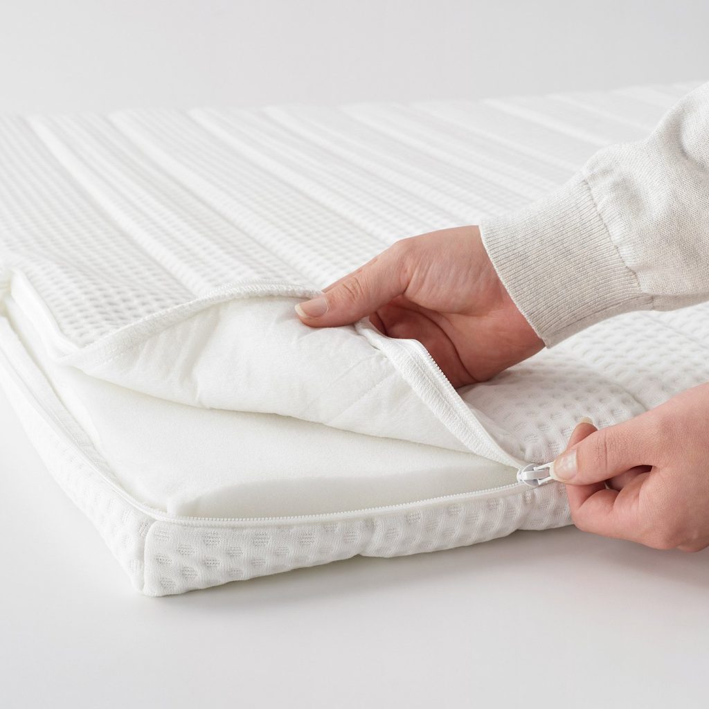 IKEA Nisseholm mattress pad with the quilted cover being unzipped