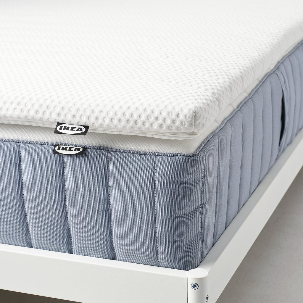 IKEA Nisseholm mattress pad on a blue sprung mattress, side view of the 5 cm foam layer
