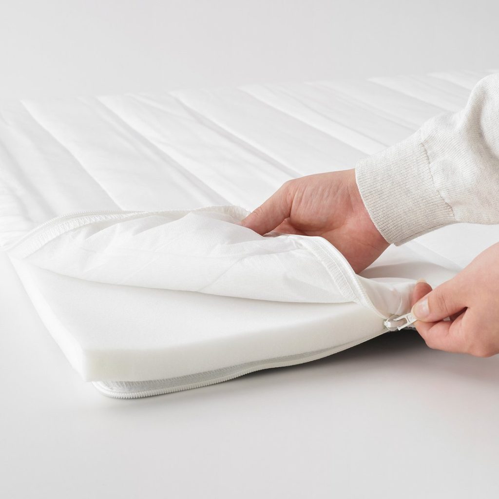 IKEA Nopakte mattress pad with the cover unzipped to show the foam
