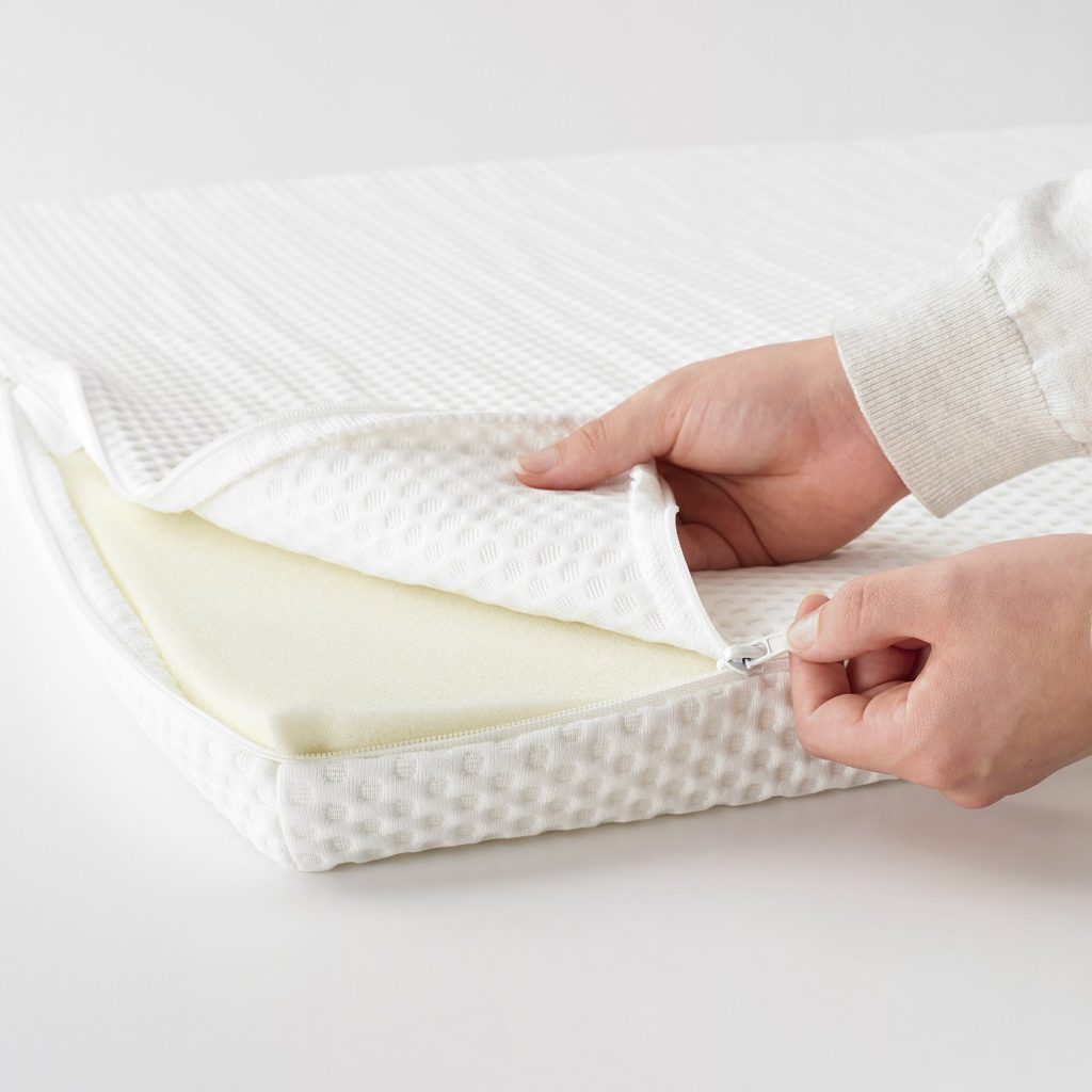 IKEA Nordberget mattress pad with the cover being unzipped from the foam