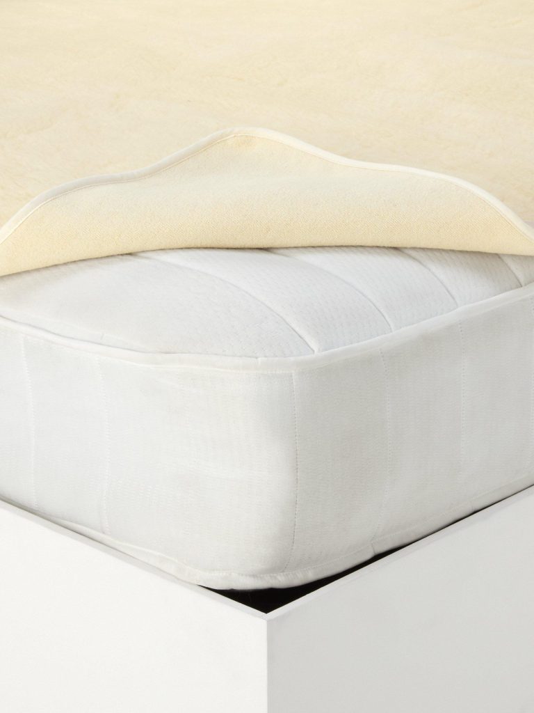 Corner of the John Lewis British Wool Fleece topper lifted from the mattress