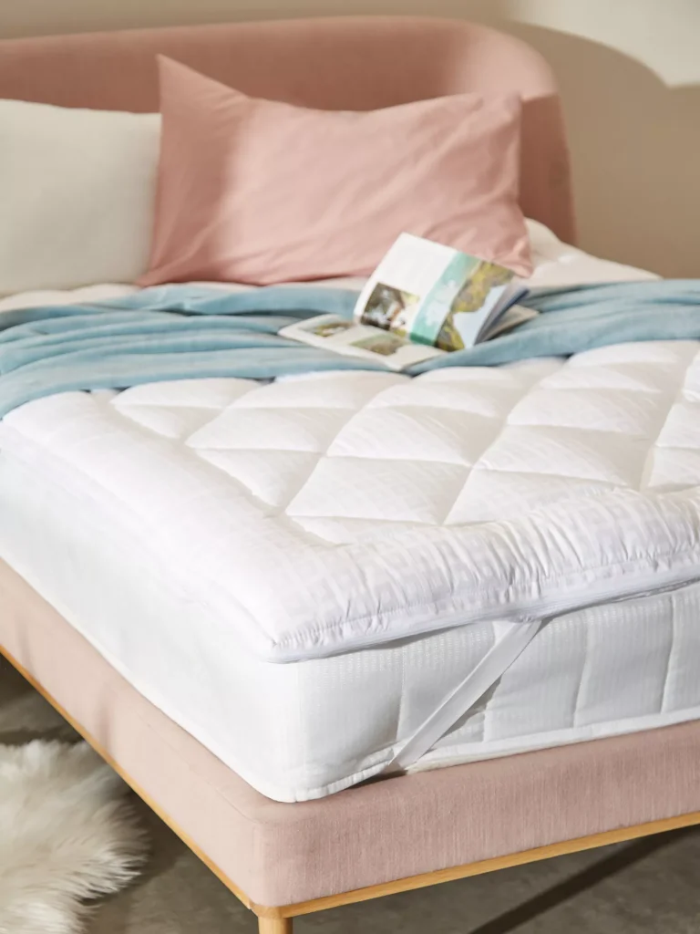John Lewis Soft Touch Washable Dual Layer topper on a bed in a bedroom