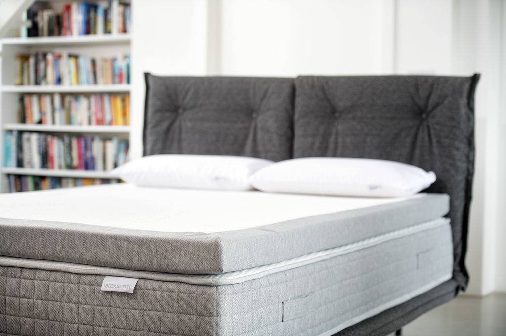 Latex Sense Firmsense topper on a made bed with a grey headboard