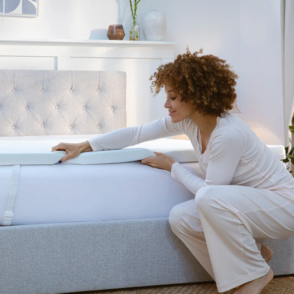 Woman fitting the Panda Bamboo Mattress Topper onto a bed