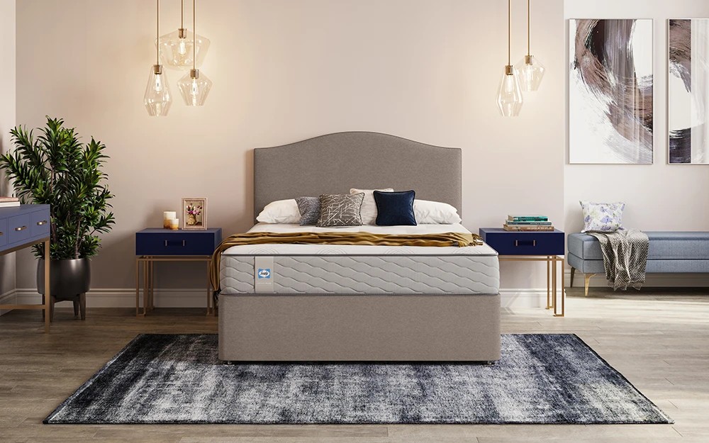 Sealy Mellbreak Ortho Plus mattress on a taupe divan bed in a bedroom with pendant lights