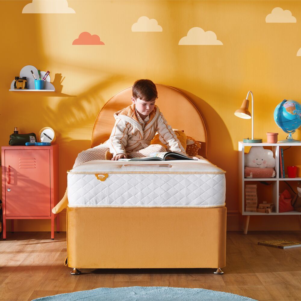 Silentnight Healthy Growth Astro Eco Comfort Pocket mattress, child reading on the mattress in a bedroom