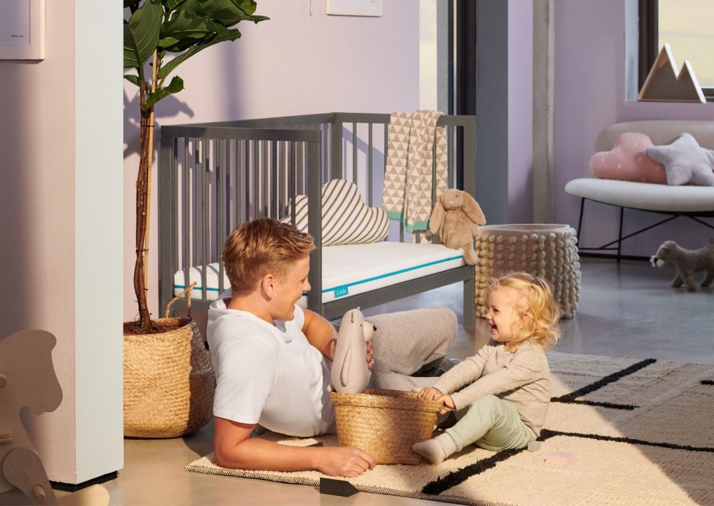 Simba Hybrid Cot Bed Mattress in a cot while a parent plays with a toddler