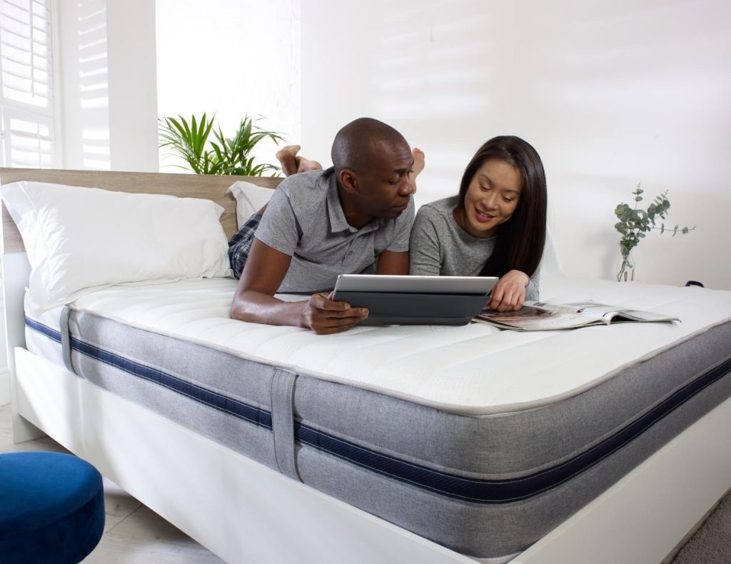 Couple relaxing on the Starlight 07 all-foam mattress in a bright bedroom