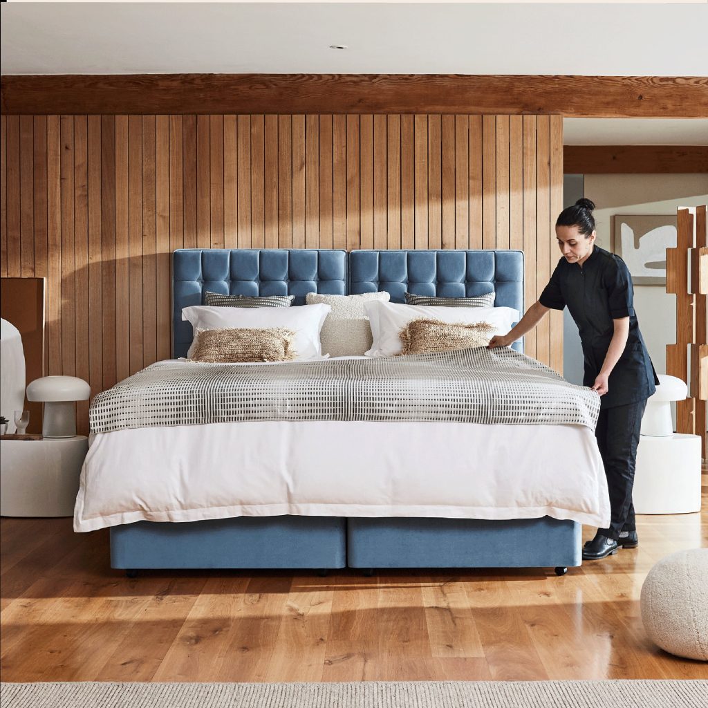 Sleepeezee Hotel Supreme 1400 mattress being made up on a blue divan bed
