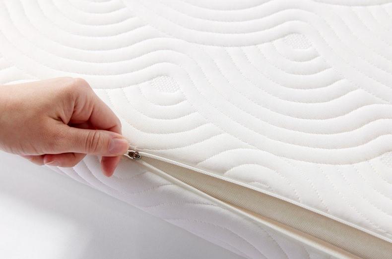 Hand unzipping the removable cover of the TEMPUR ONE Topper