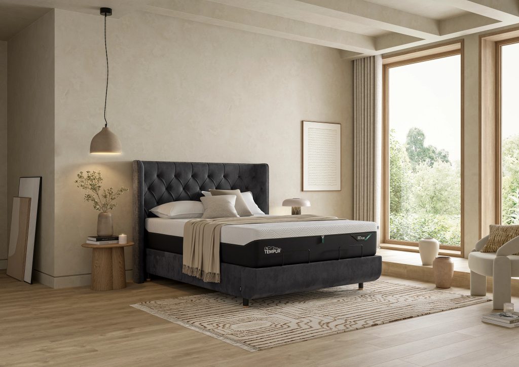 TEMPUR PRO SmartCool mattress on a bed by a window, a man smoothing the cover