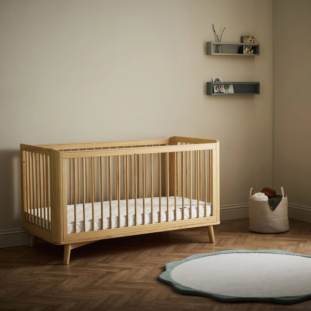 The Little Green Sheep Twist Natural Cot Bed Mattress in a wooden cot bed in a nursery