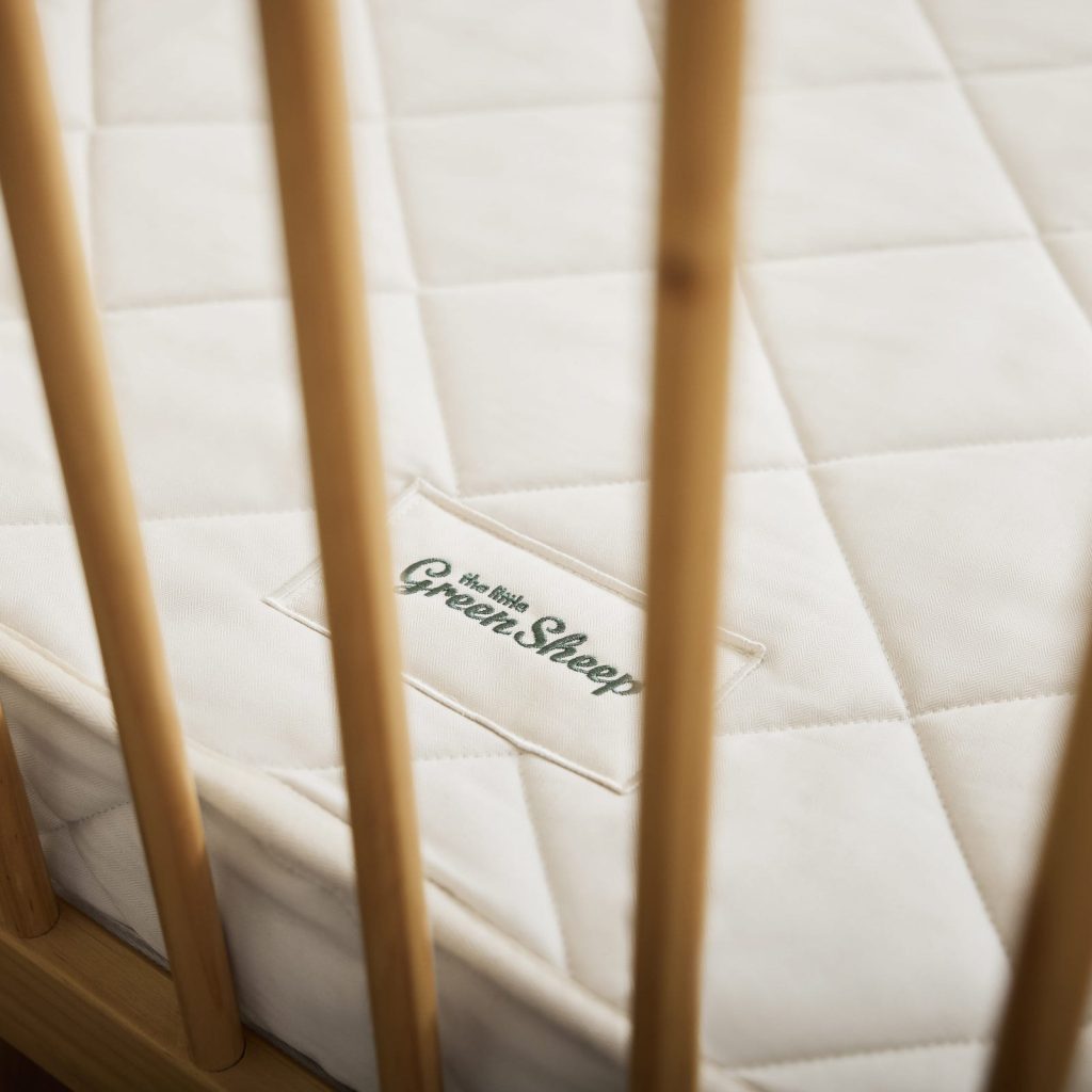 The Little Green Sheep Twist Natural Cot Bed Mattress label seen through the cot bars