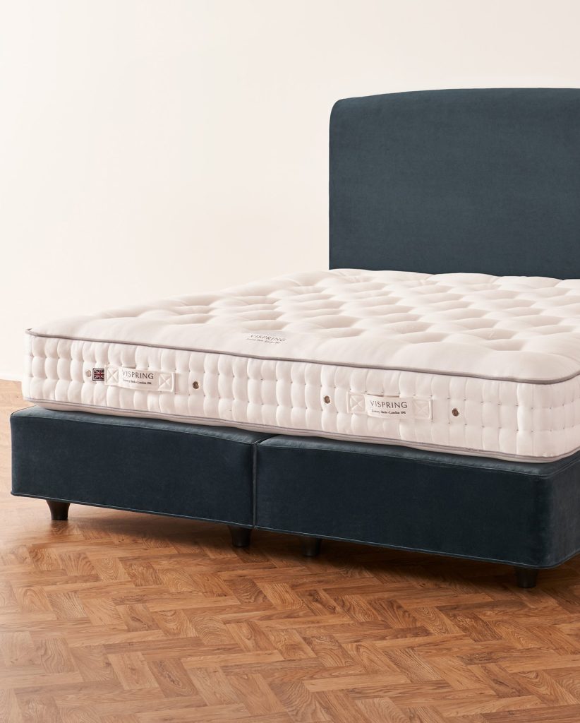 Vispring Herald Superb mattress on a navy velvet divan with headboard