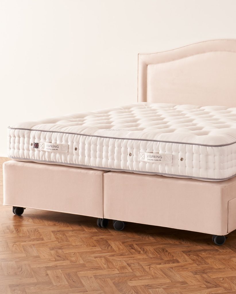 Vispring Regal Superb mattress on a pale pink divan with a curved headboard