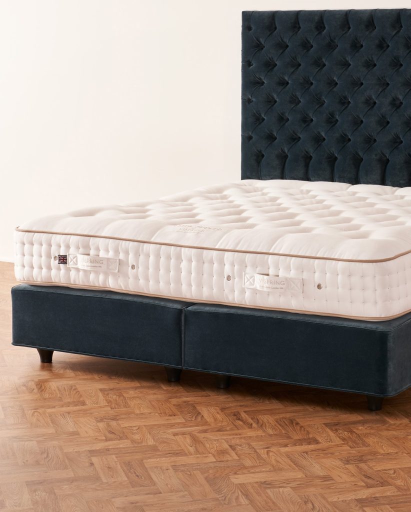 Vispring Tiara Superb mattress on a navy velvet divan with buttoned headboard