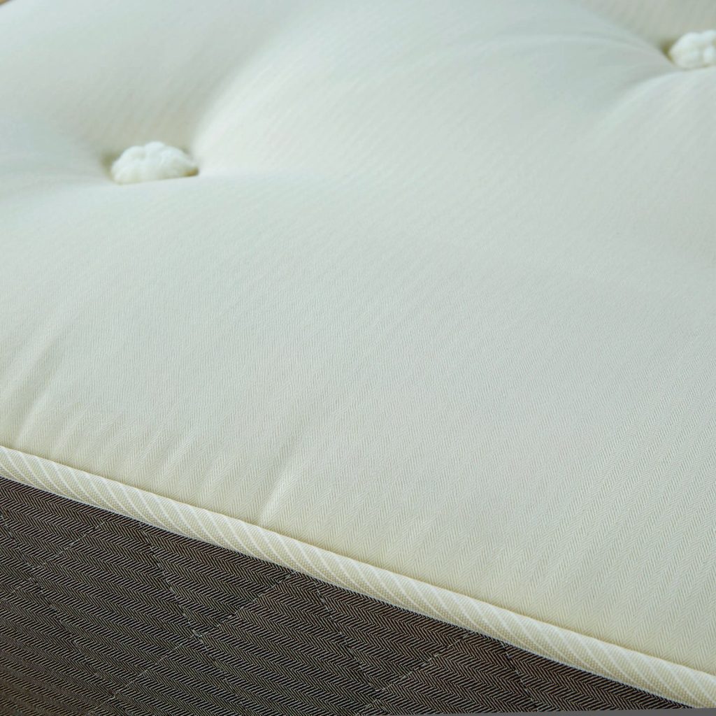 Close-up of the organic cotton cover and tufting on the Woolroom Junior