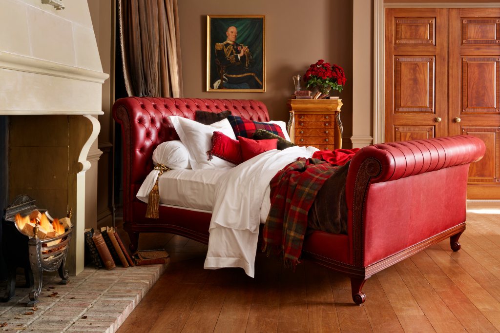 And So To Bed Bonaparte Deep Buttoned Bed in red leather beside a fireplace