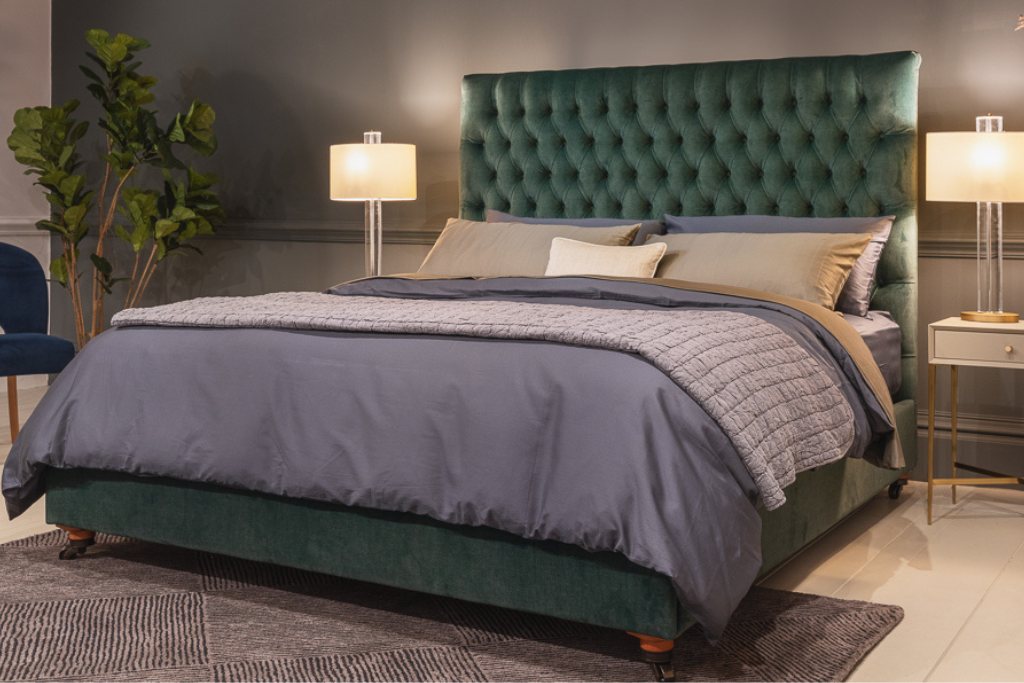 And So To Bed Emilia Grand Bed in green velvet seen from an angle in a grey bedroom