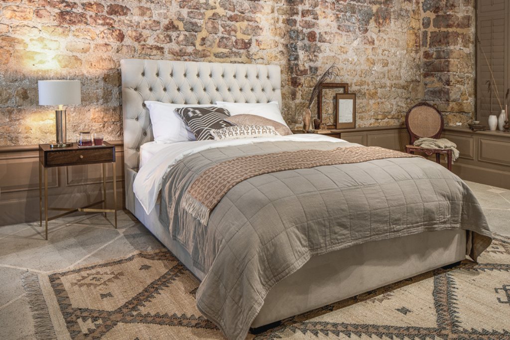 And So To Bed Emilia Ottoman Bed seen from an angle on a patterned rug