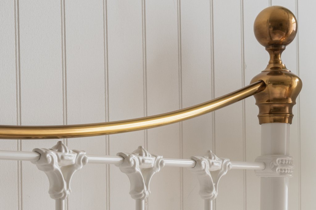 And So To Bed Juniper Bed close-up of the brass cannonball knob and white castings