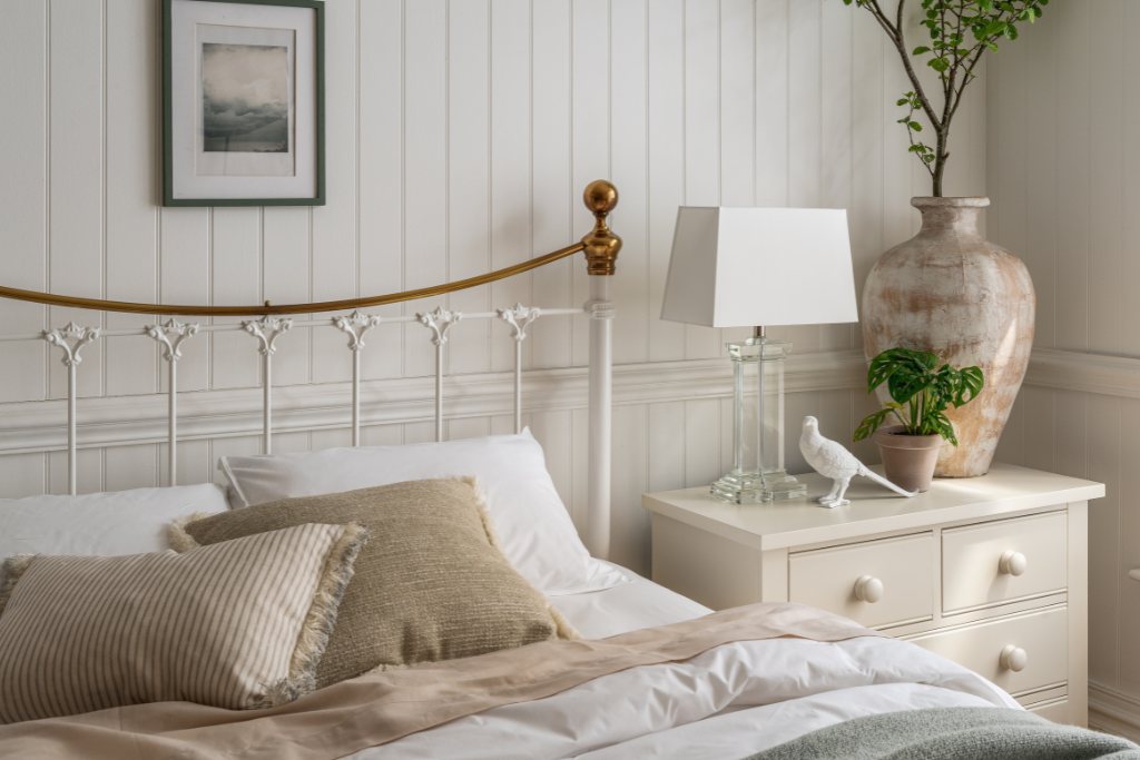 And So To Bed Juniper Bed headboard with brass rail behind a made-up bed
