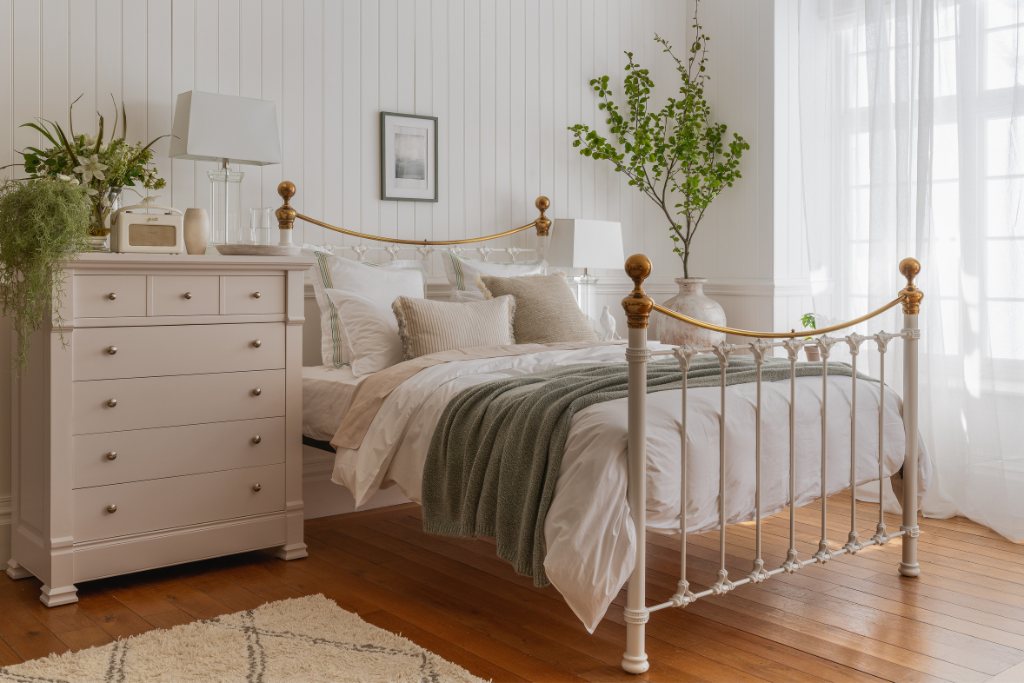 And So To Bed Juniper Bed seen from an angle next to a cream chest of drawers