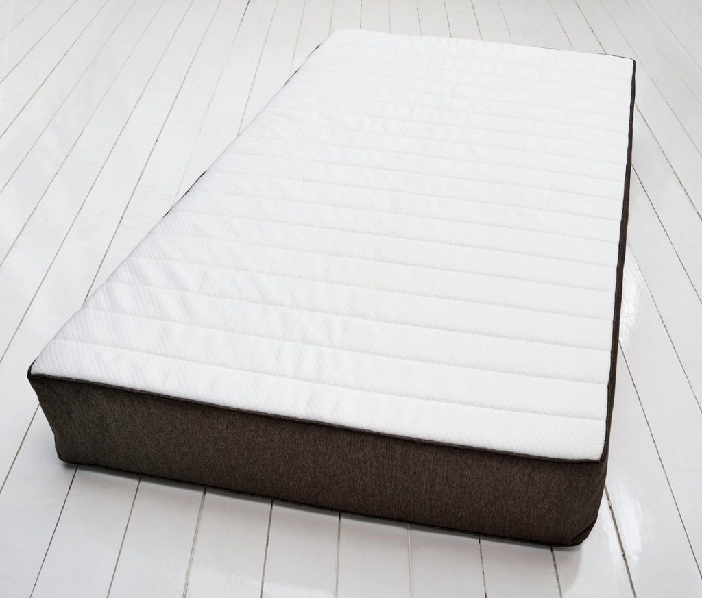 Argos Home Open Coil mattress on a white wooden floor, angled view