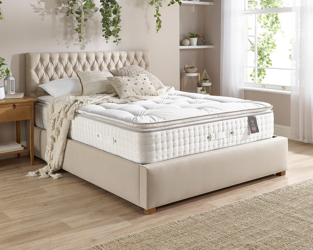 Aspire 7000 Pillowtop mattress on a beige upholstered bed, seen from an angle