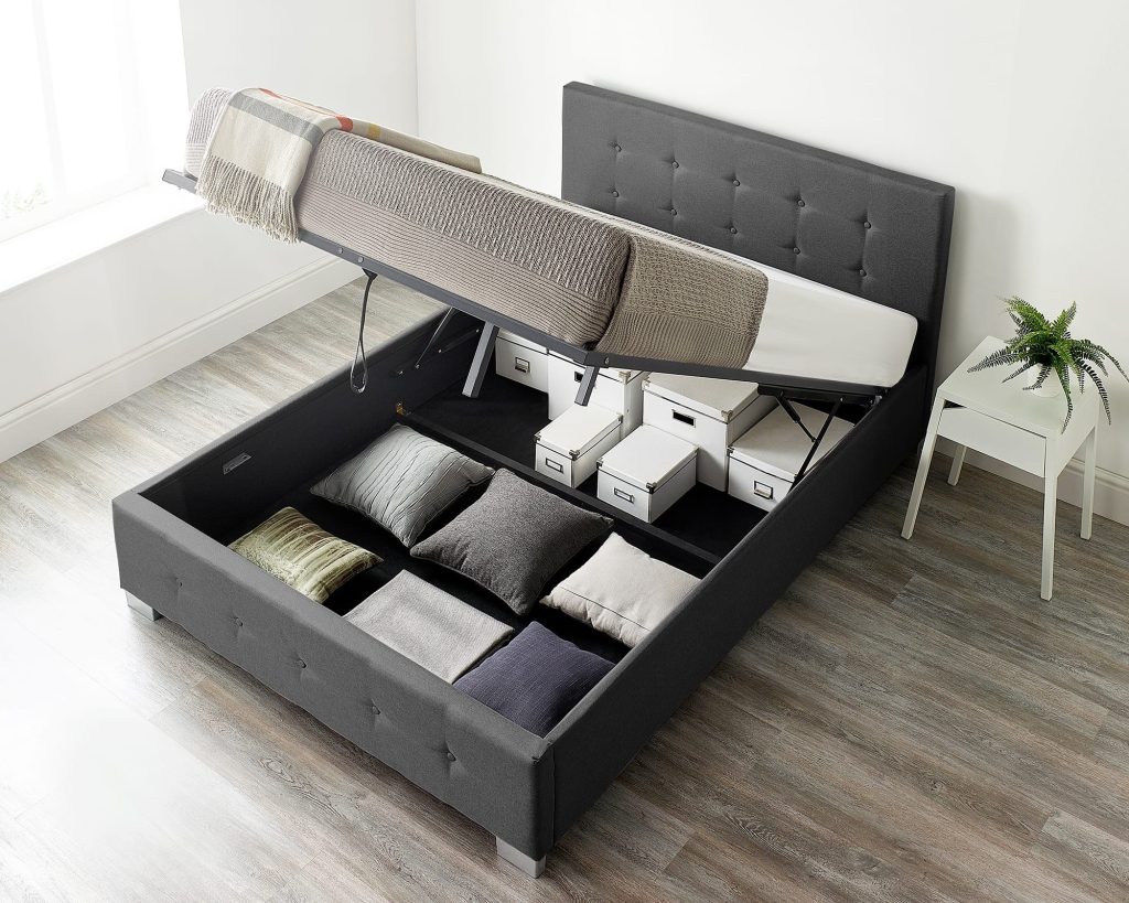 Aspire End Lift Ottoman Storage Bed with the base lifted and folded bedding in the storage well