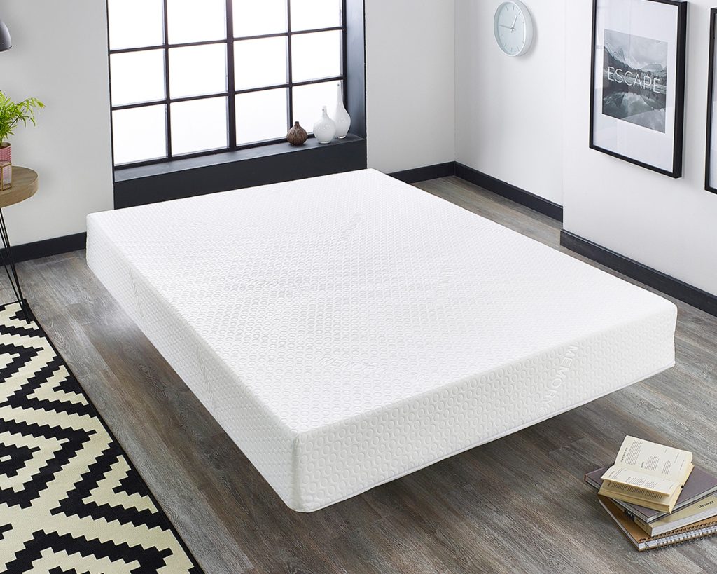 Aspire Essentials Memory Foam mattress lying on a wooden floor beside a patterned rug