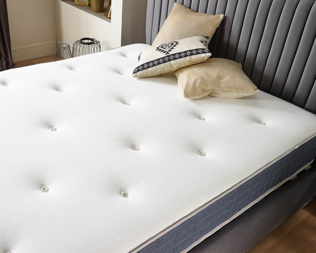 Aspire Pocket+ 1000 Duo Tufted Dual Sided Mattress on a grey bed with cushions