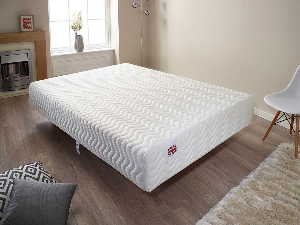 Aspire Total Relief mattress on a low base in a bright room with a wooden floor
