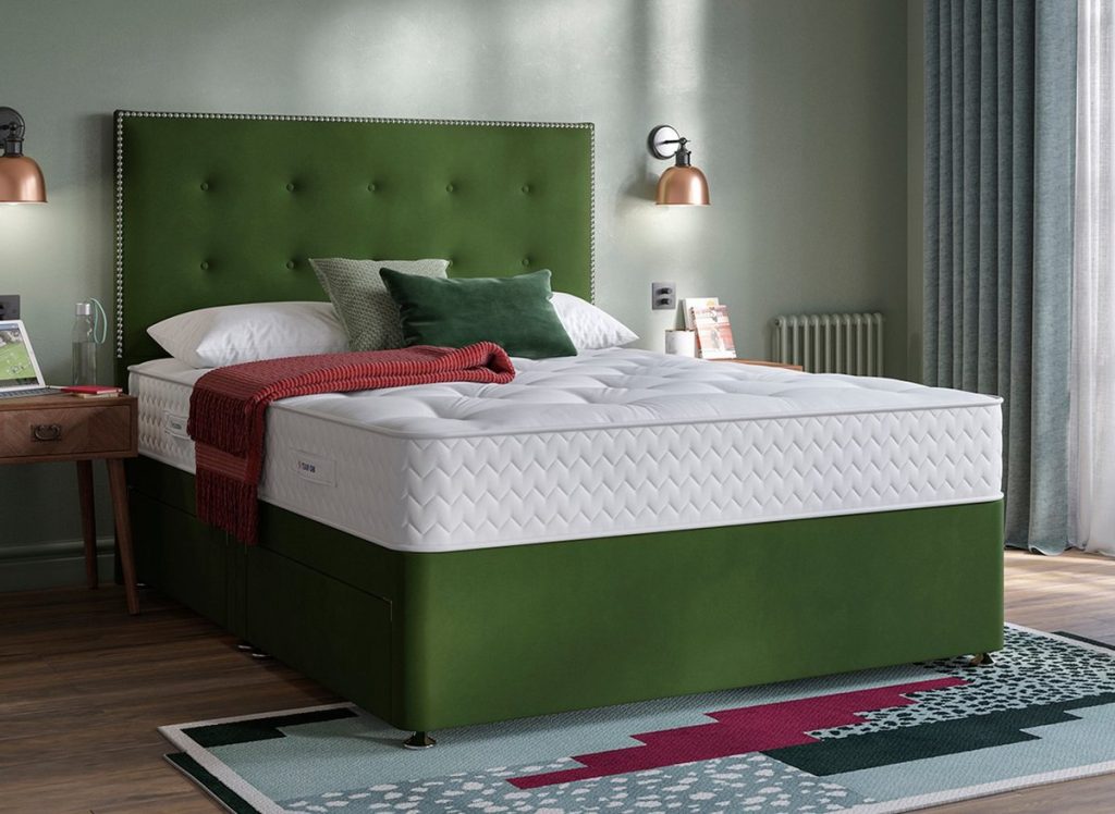 Dream Team Fakenham mattress on a green velvet divan bed in a bedroom