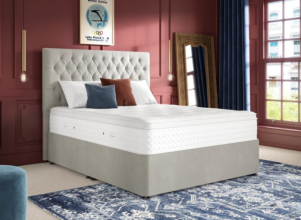 Dream Team Gold Lynmouth mattress on a grey divan bed in a red-walled bedroom